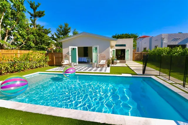 a view of swimming pool with lawn chairs and a yard