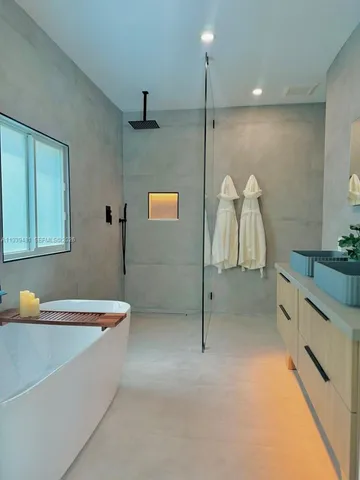 a bathroom with a tub sink and mirror