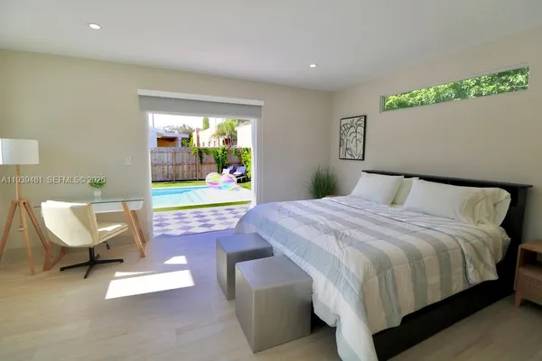 a bedroom with a bed chair and window