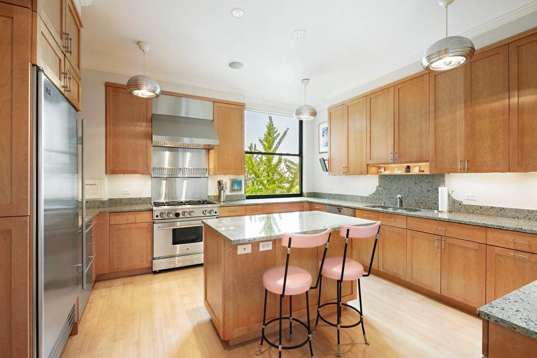 1 Sutton Place South, Unit 7C Manhattan, NY 10022 - Photo 10 of 16 a kitchen with stainless steel appliances granite countertop a stove top oven a sink dishwasher a dining table and chairs with wooden floor