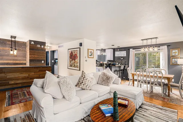 a living room with furniture and a dining table with wooden floor