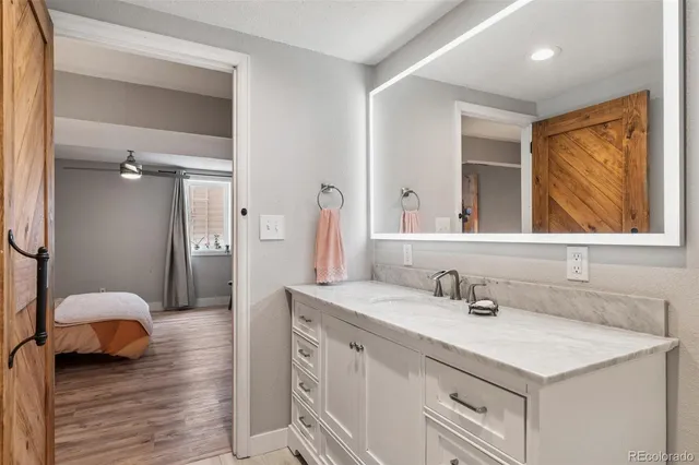 a bathroom with a granite countertop toilet sink and mirror