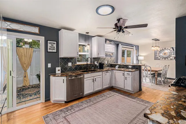 a kitchen with granite countertop a stove a sink and a refrigerator