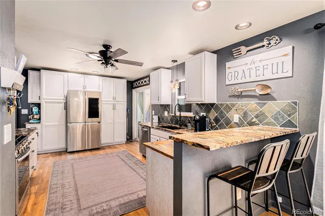 a kitchen with stainless steel appliances kitchen island granite countertop a refrigerator and a stove top oven