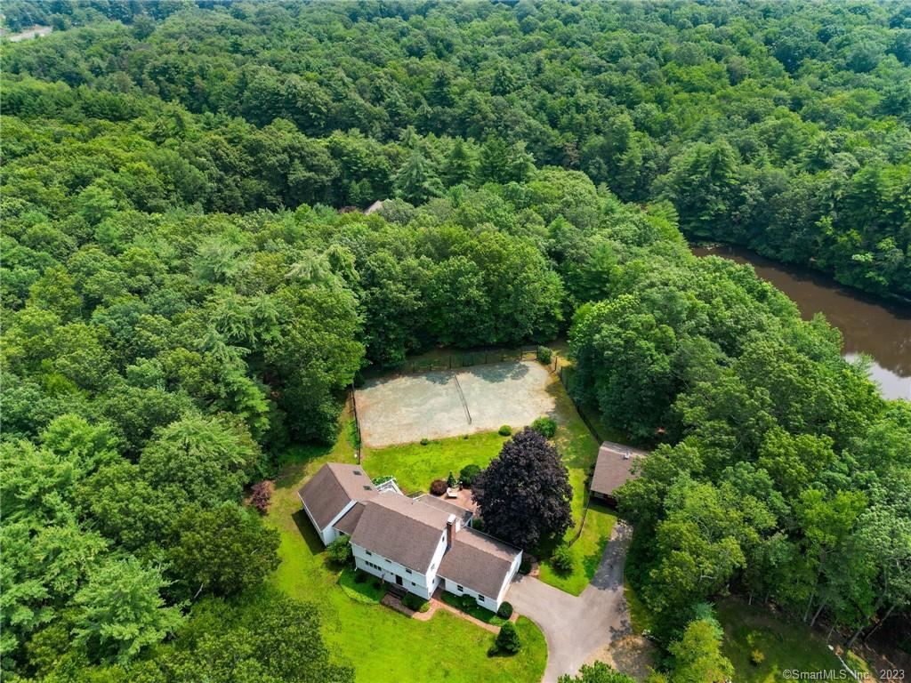 an aerial view of residential house with outdoor space and trees all around