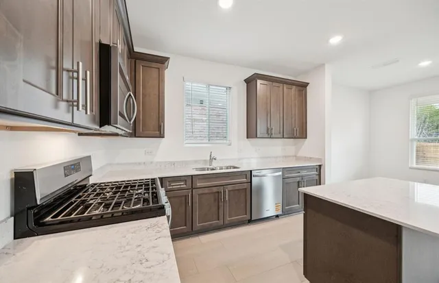 a kitchen with stainless steel appliances a sink stove and cabinets