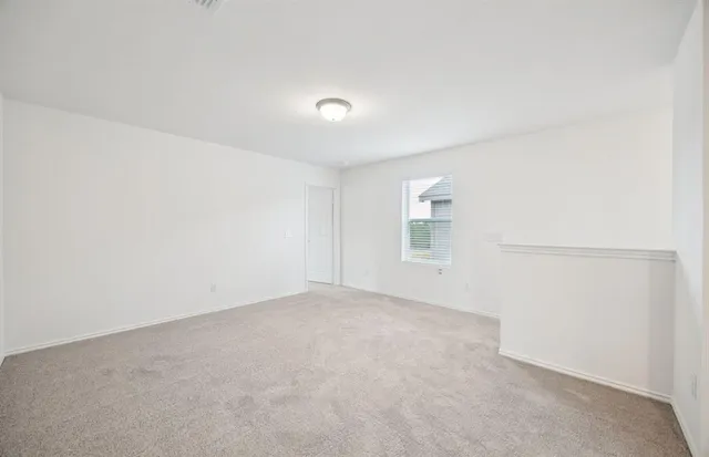 an empty room with white wall and windows
