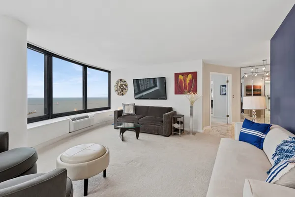 a living room with furniture a large window and a flat screen tv