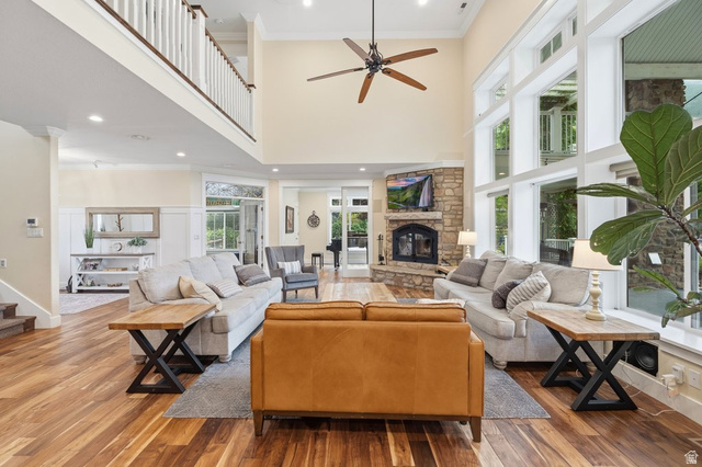 672 Perry Hollow Drive Mapleton, UT 84664 - Photo 24 of 106 Spacious living area featuring high vaulted ceilings, expansive windows, a stone-faced fireplace, wood-finish flooring, and an upper-level balcony with white railings