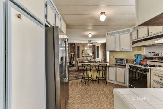 1975 East Burns Avenue Ridgecrest, CA 93555 - Photo 28 of 43 a kitchen with stainless steel appliances granite countertop a sink a stove and a refrigerator