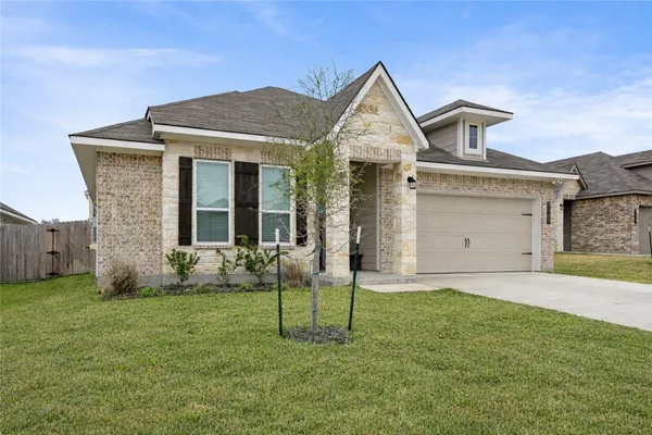 a front view of a house with a yard and garage