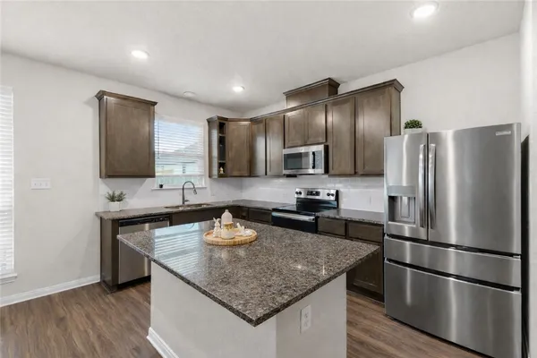 a kitchen with a refrigerator a sink and a stove