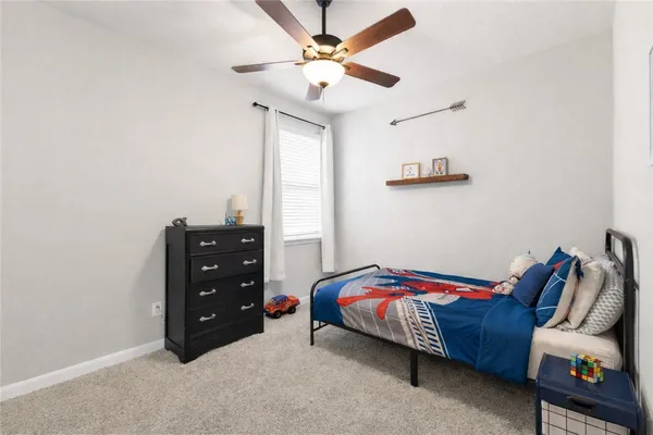 a bedroom with a bed and a ceiling fan