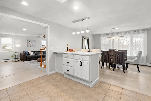 a living room with furniture a dining table a counter space and a window