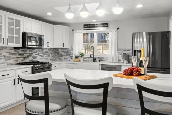 a kitchen with a dining table chairs sink and microwave