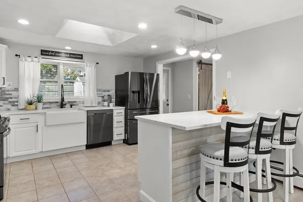 a kitchen with a table chairs refrigerator and cabinets