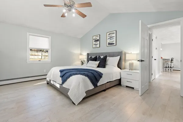 a bedroom with a large bed and a chandelier