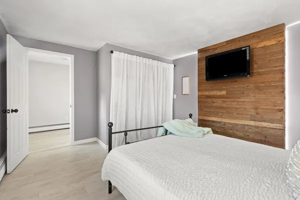a bedroom with a bed and a flat screen tv