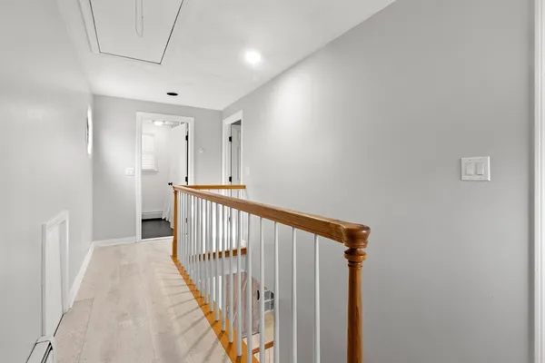 a view of a hallway with wooden floor and entryway