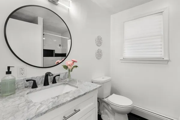 a bathroom with a granite countertop sink mirror and toilet