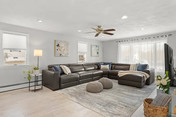 a living room with furniture ceiling fan and a window