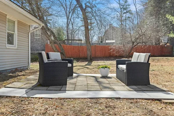 a view of a patio with table and chairs with wooden fence
