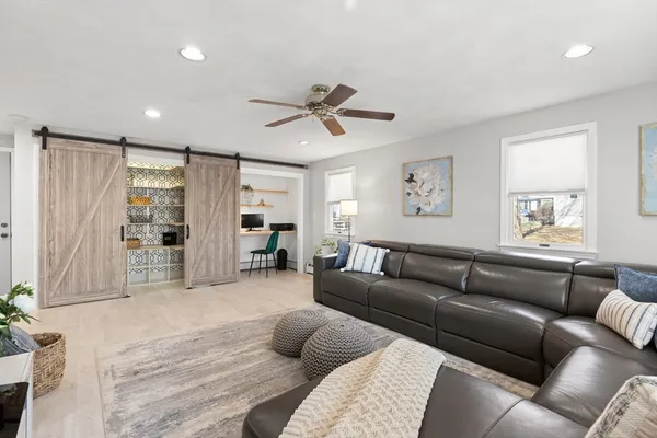 a living room with furniture ceiling fan and a window