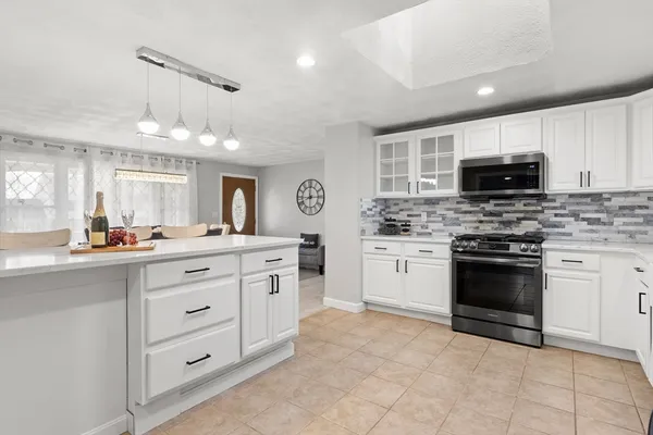 a kitchen with granite countertop a stove sink and cabinets