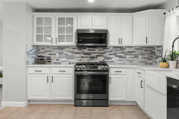 a kitchen with white cabinets and appliances