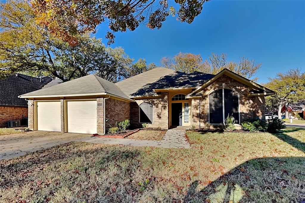 Ranch-style house with a front yard, concrete driveway, brick siding, a shingled roof, and a garage