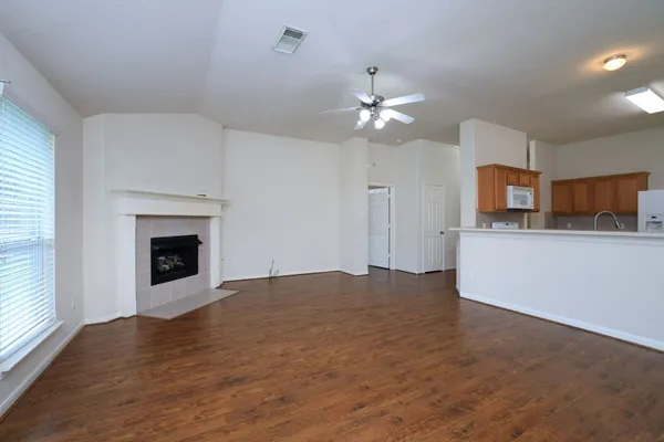 a view of an empty room with a fireplace and a window
