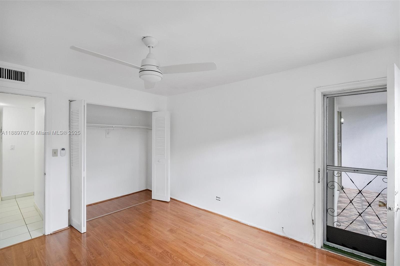8107 Southwest 72nd Avenue, Unit 201E Miami, FL 33143 - Photo 16 of 29 a view of an empty room with wooden floor and a window