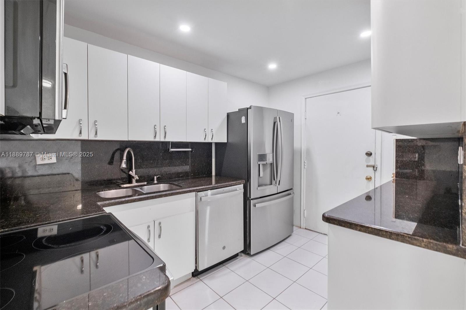 8107 Southwest 72nd Avenue, Unit 201E Miami, FL 33143 - Photo 5 of 29 a kitchen with stainless steel appliances a sink a stove a refrigerator a sink and cabinets