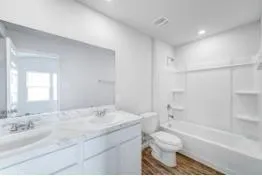a bathroom with a granite countertop sink toilet tub and shower