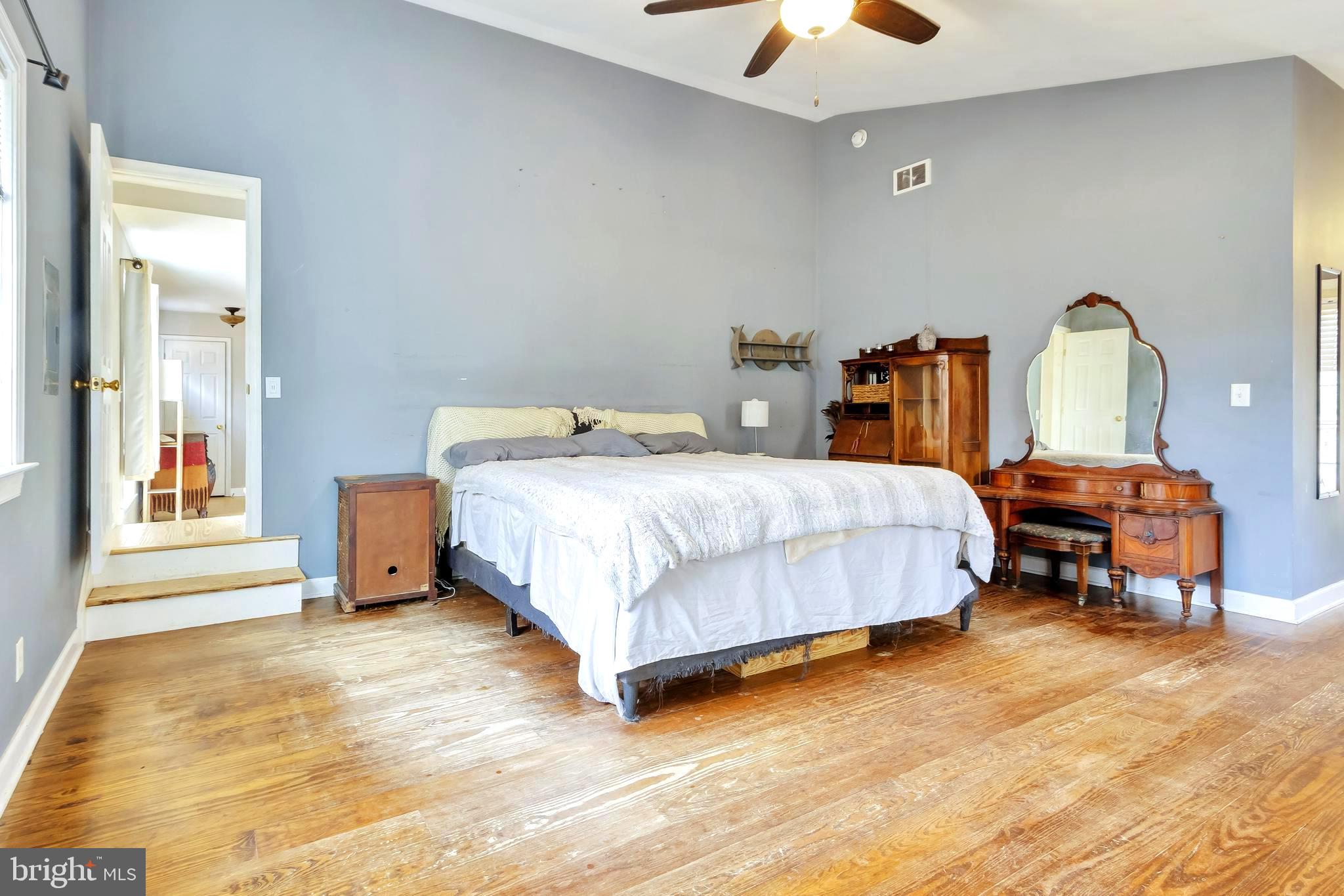 18526 Cool Spring Road Milton, DE 19968 - Photo 17 of 70 a bedroom with a bed a chandelier and a dresser
