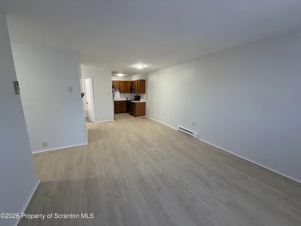 a view of empty room with wooden floor