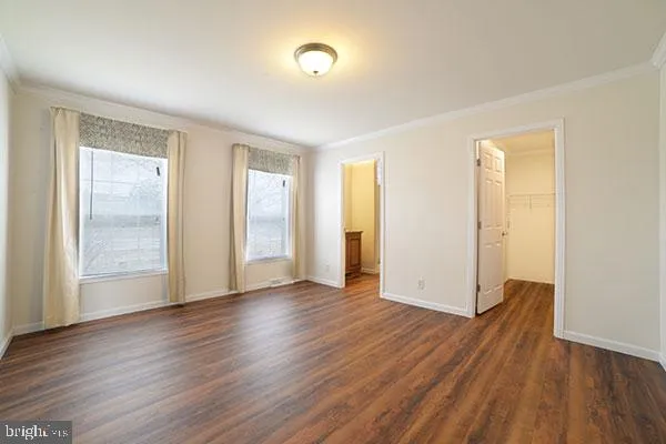 an empty room with wooden floor and a window