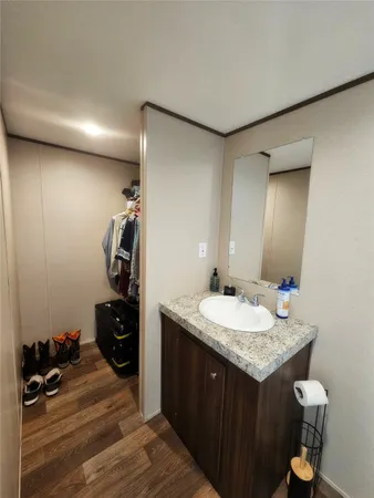 a bathroom with a granite countertop toilet sink and mirror