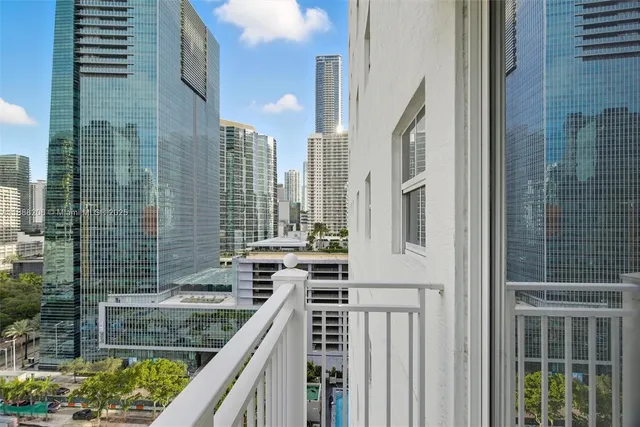 a view of balcony with a couple of cars parked in front of door