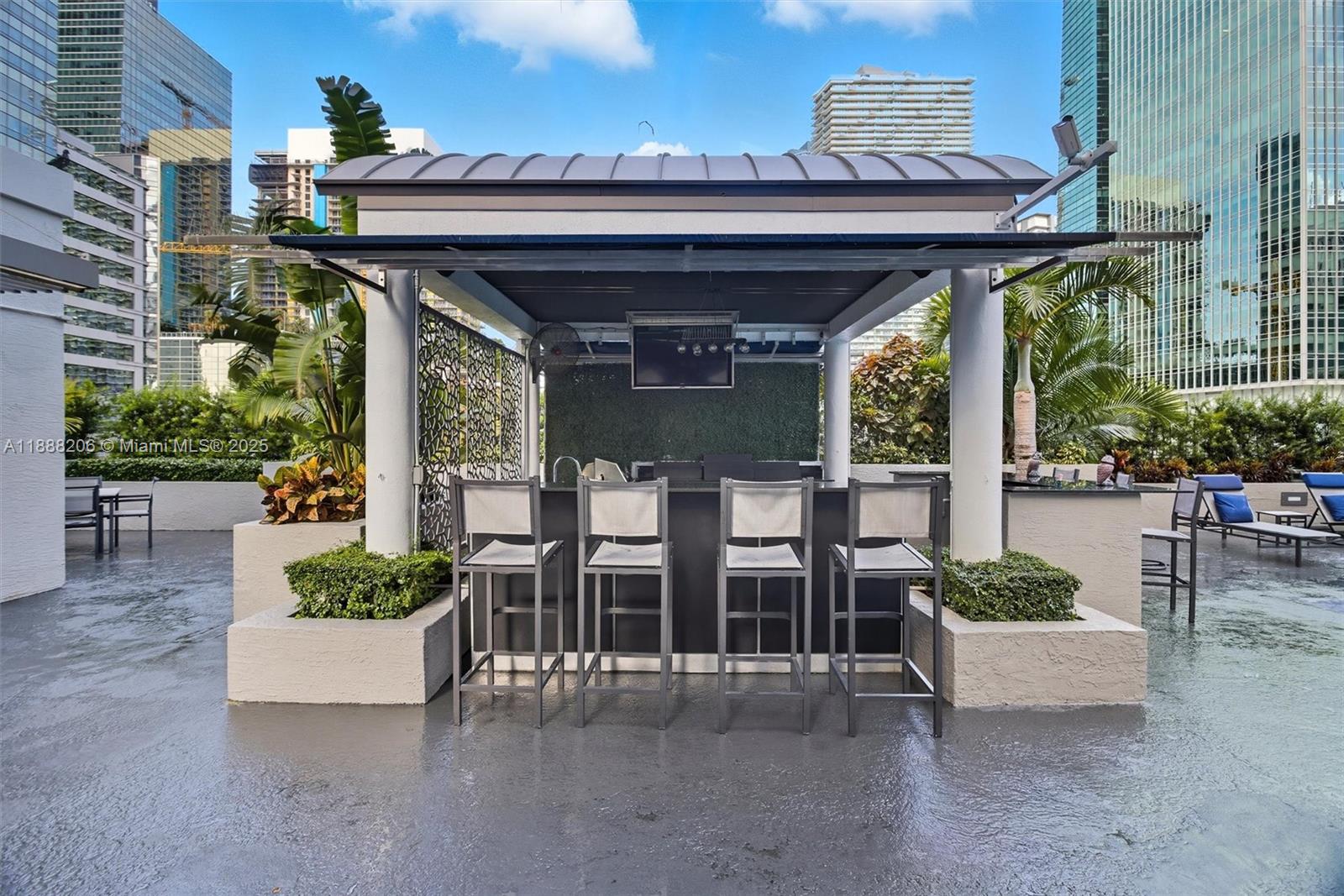 185 Southeast 14th Terrace, Unit 1709 Miami, FL 33131 - Photo 19 of 31 a view of a patio with table and chairs potted plants