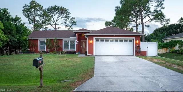 a front view of a house with a yard and a garage