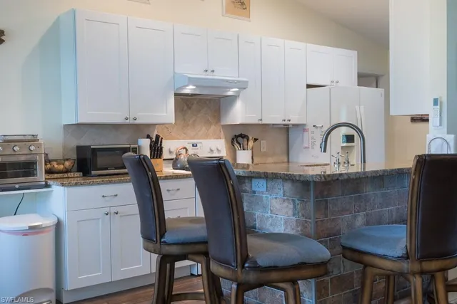 a kitchen with a table chairs sink and cabinets