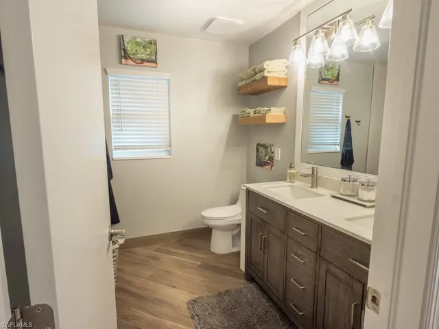 a bathroom with a granite countertop sink toilet and mirror