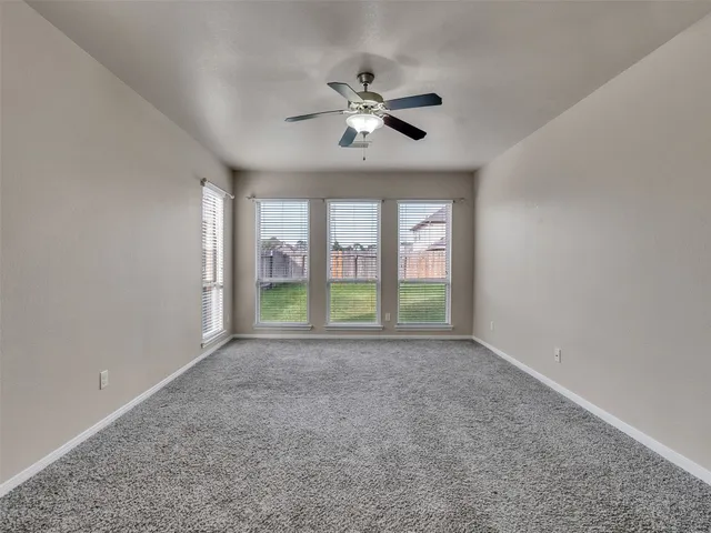 a view of an empty room with a ceiling fan