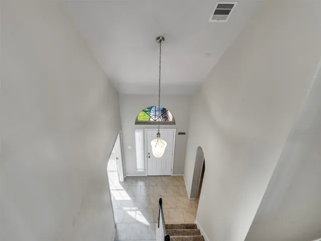a view of a hallway to a room with wooden floor