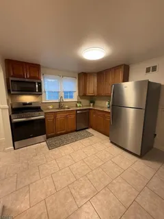 a kitchen with granite countertop a refrigerator and a stove top oven