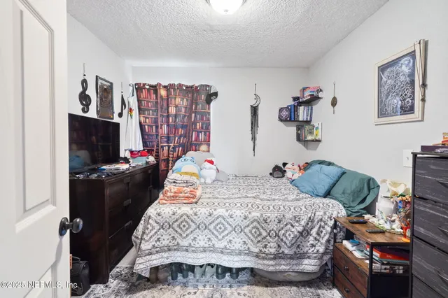 a bedroom with a bed and flat screen tv