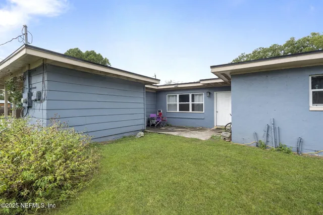 a view of a house with a yard and sitting area