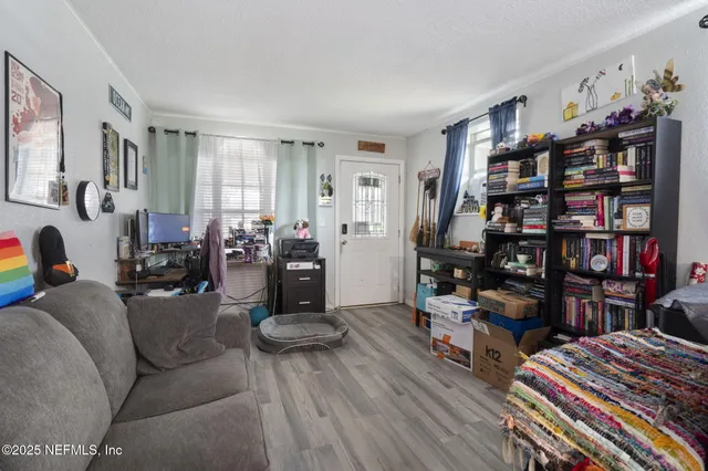 a living room with furniture a bookshelf and a window