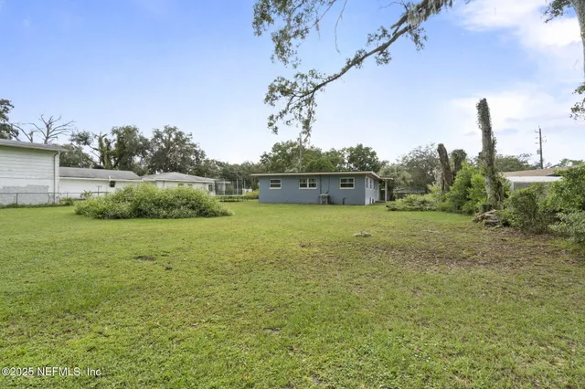a view of an house with backyard and tub